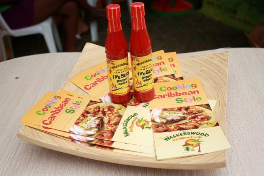 Two bottles of caribbean sauce on a tray.