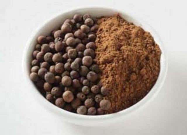 A bowl of cocoa powder and black pepper in a white bowl.