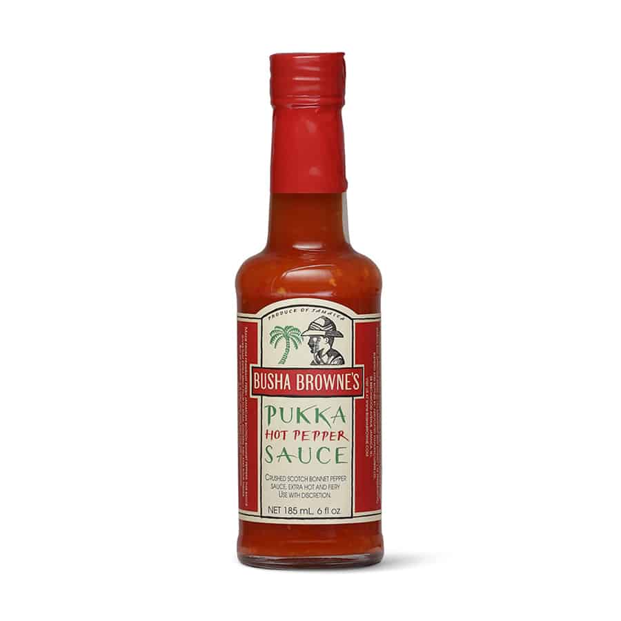 A bottle of Busha Browne's Pukka Hot Pepper Sauce on a white background.