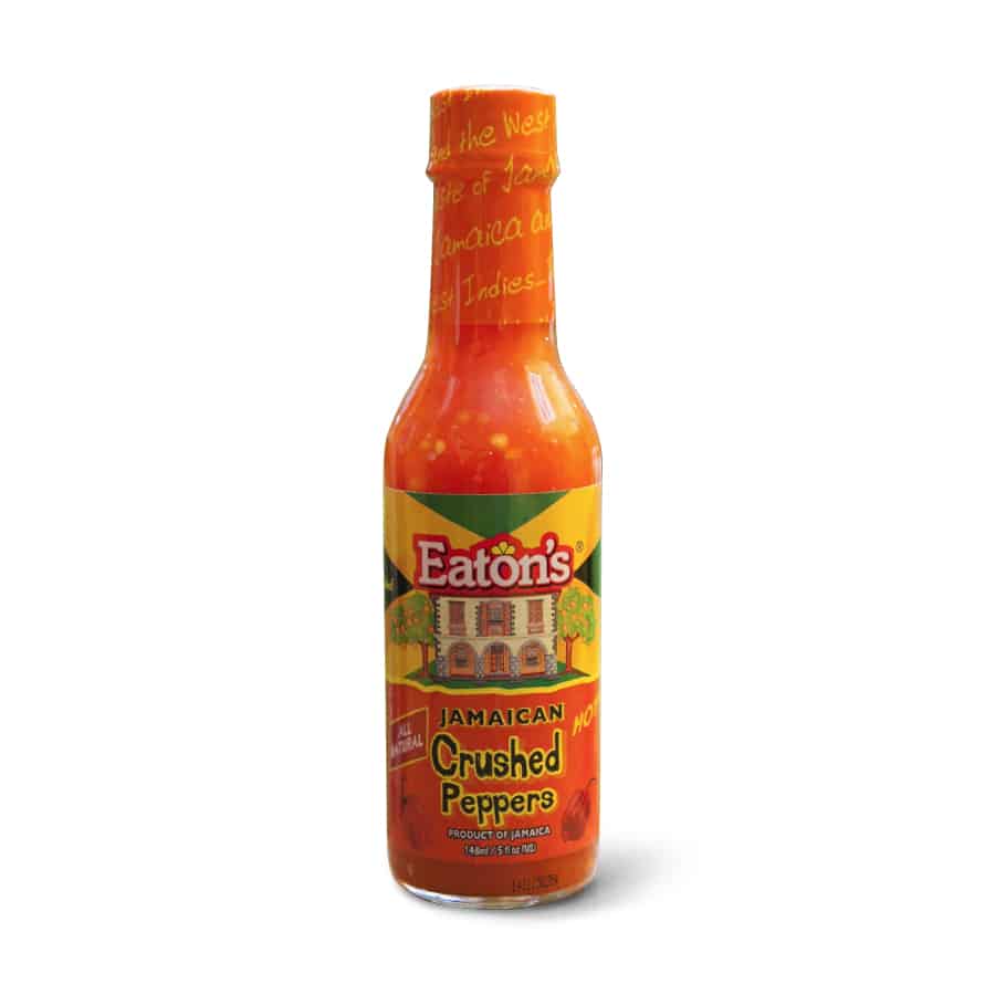 A bottle of Eaton's Jamaican Crushed Peppers 148ml hot sauce on a white background.